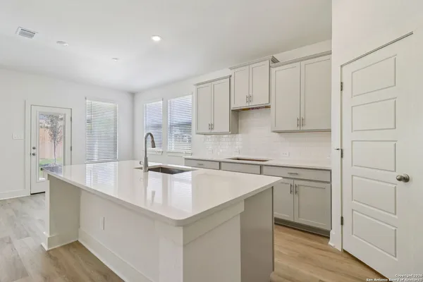 a kitchen that has a sink a stove and cabinets