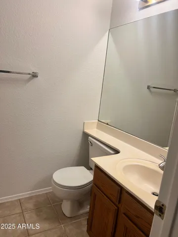 a white toilet sitting next to a white sink and vanity