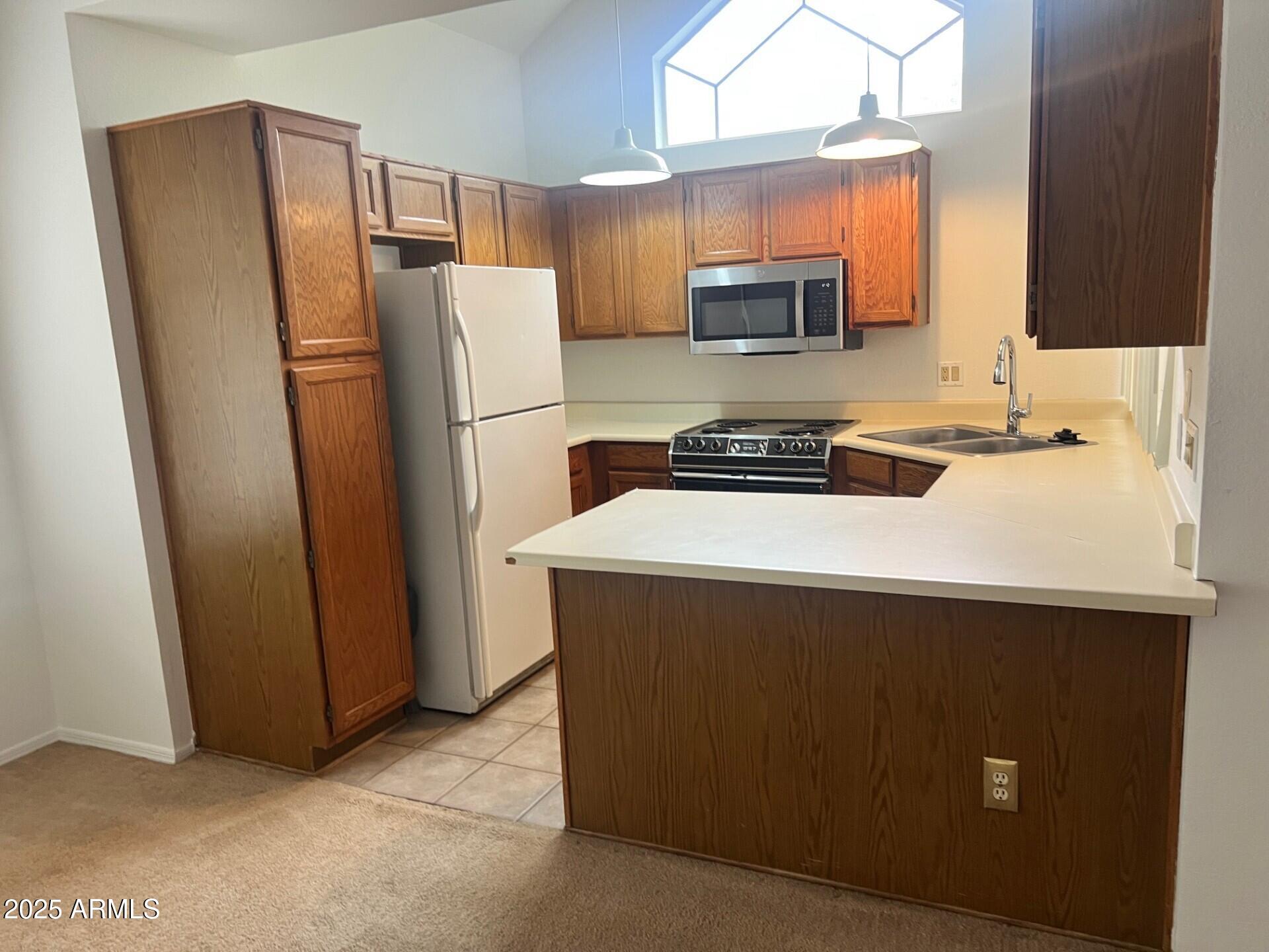 1633 East Lakeside Drive, Unit 17 Gilbert, AZ 85234 - Photo 3 of 19 a kitchen with stainless steel appliances a refrigerator and a stove