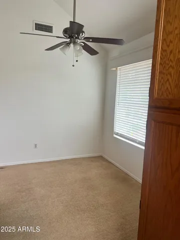 a view of a room with a window and a ceiling fan