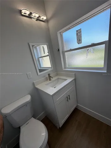 a bathroom with a toilet sink a mirror and vanity