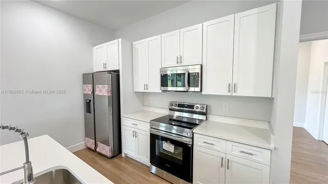 a kitchen with stainless steel appliances a stove a refrigerator and cabinets