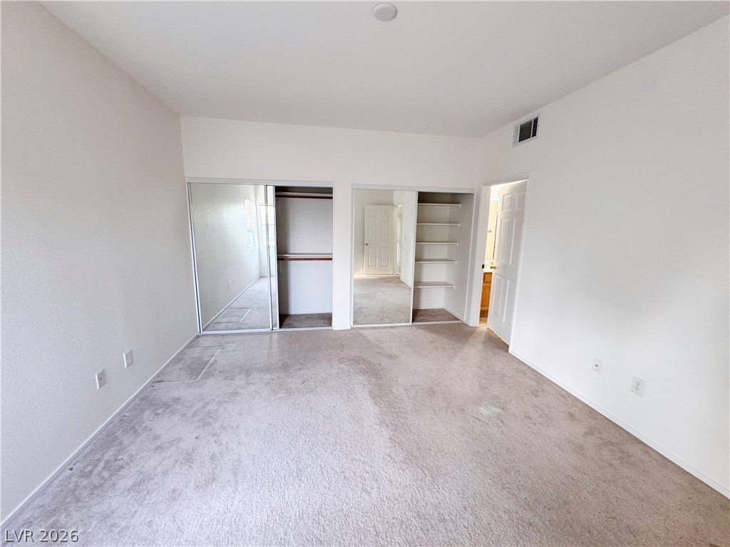 9580 West Reno Avenue, Unit 242 Las Vegas, NV 89148 - Photo 15 of 26 A well-lit bedroom features plush carpeting and convenient mirrored closet doors.