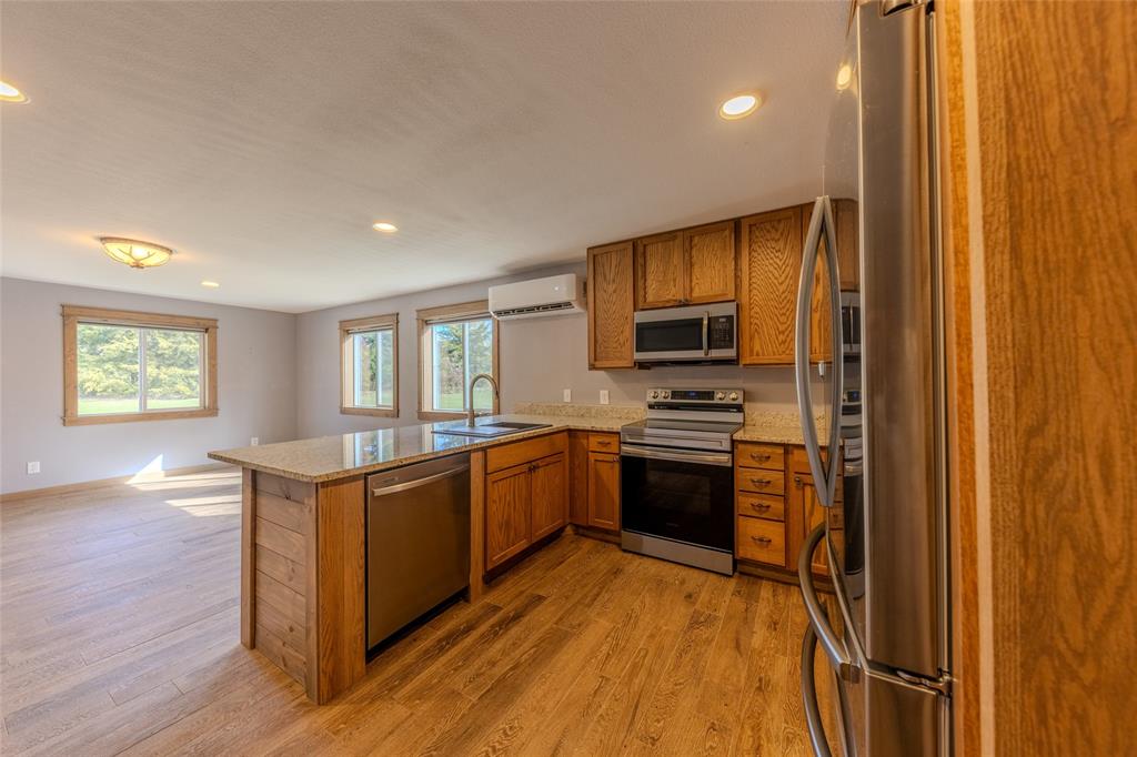 984 County Rd SE 4350 Scroggins, TX 75480 - Photo 14 of 35 a kitchen with stainless steel appliances granite countertop a stove a sink dishwasher and a refrigerator with wooden floor