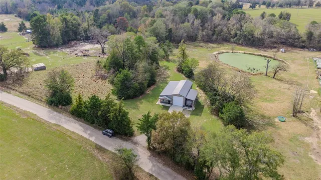 an aerial view of a house with a yard and lake view
