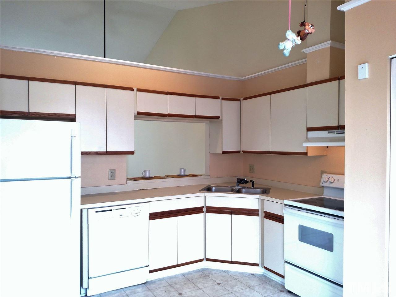 131 Renwick Court Raleigh, NC 27615 - Photo 4 of 21 a kitchen with kitchen island a sink a stove and white cabinets