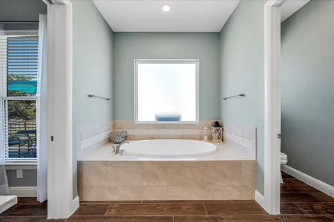 a bathroom with bathtub a shower a sink and a window