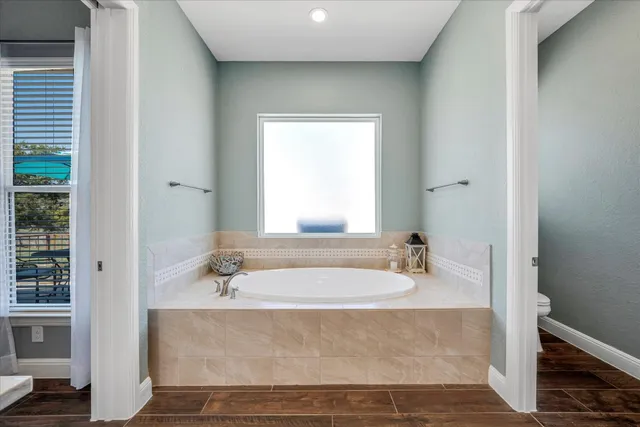 a bathroom with bathtub a shower a sink and a window