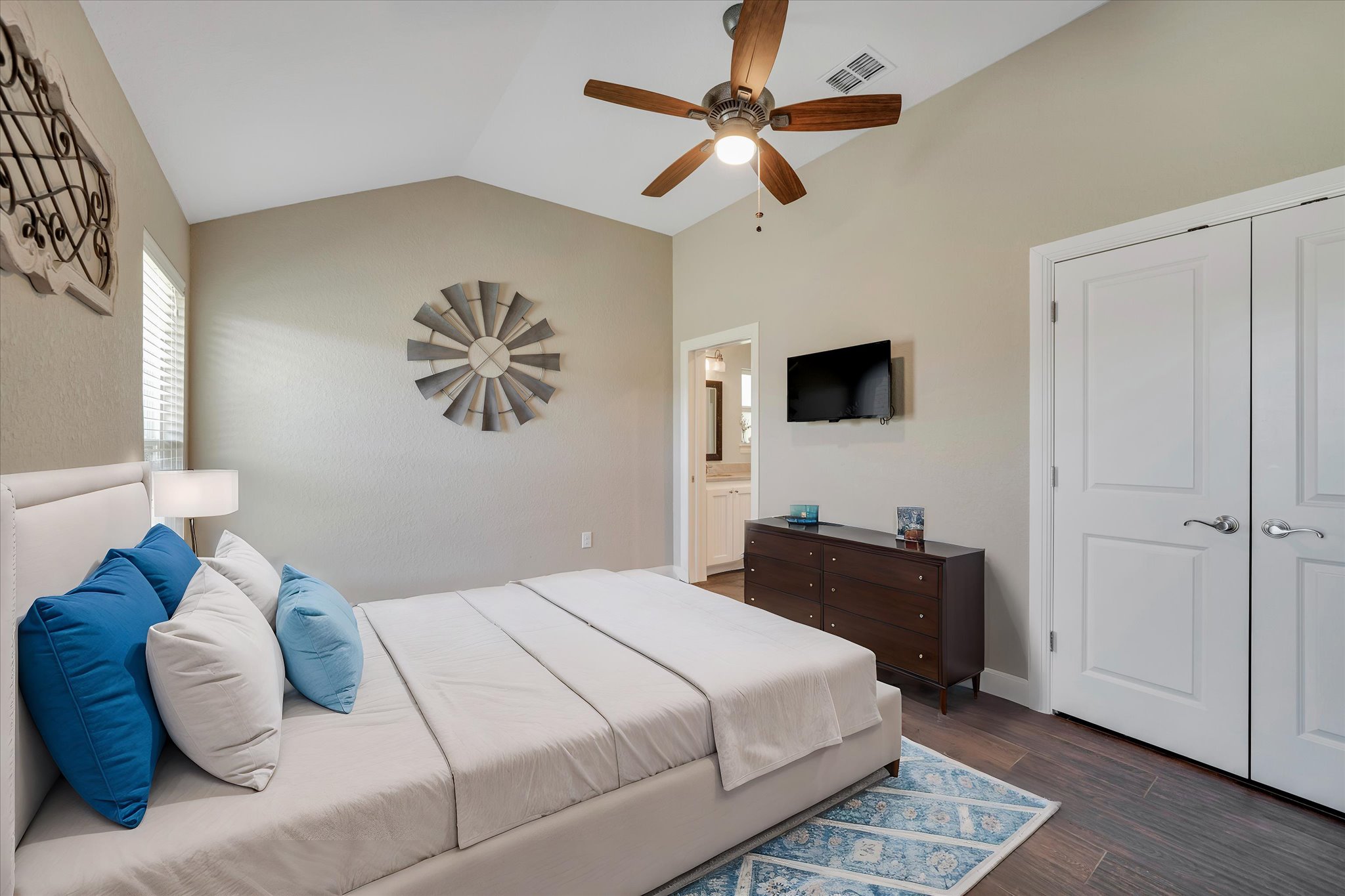 204 West Blanco Bend Drive Wimberley, TX 78676 - Photo 25 of 34 a bedroom with a large bed and a flat tv screen on a dresser