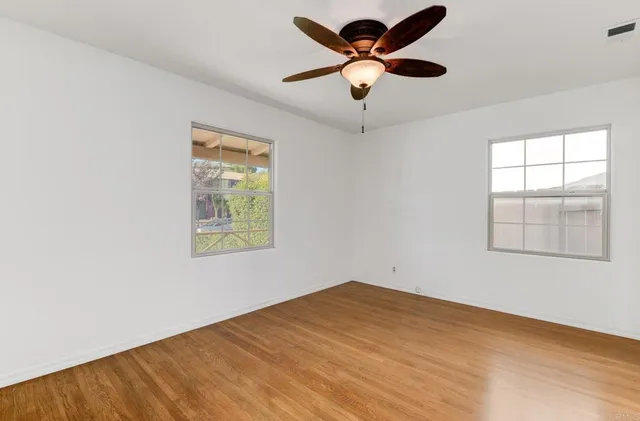 an empty room with a window and a fan