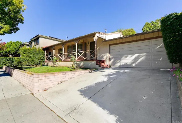 a front view of a house with a yard and potted plants
