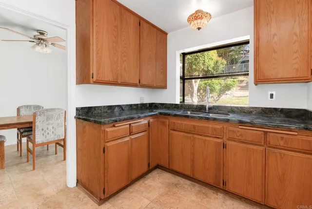 a kitchen with granite countertop a sink cabinets and window