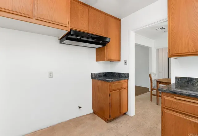 a kitchen with stainless steel appliances granite countertop cabinets and a wooden floor