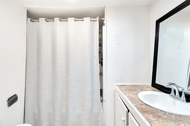 a bathroom with a granite countertop sink and a mirror