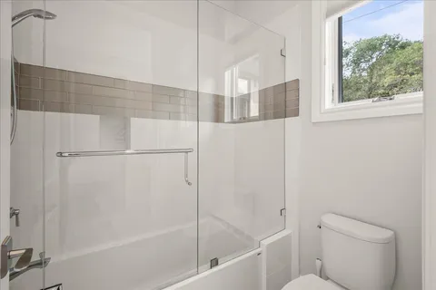 a bathroom with a shower and a glass door