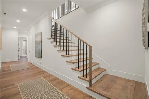 a view of a patio with couches and table and chairs under an umbrella with large trees