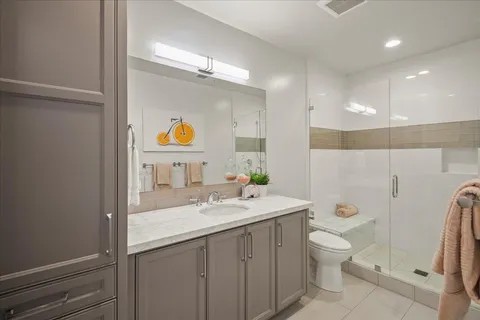 a view of backyard with table and chairs and a barbeque with potted plants and large trees