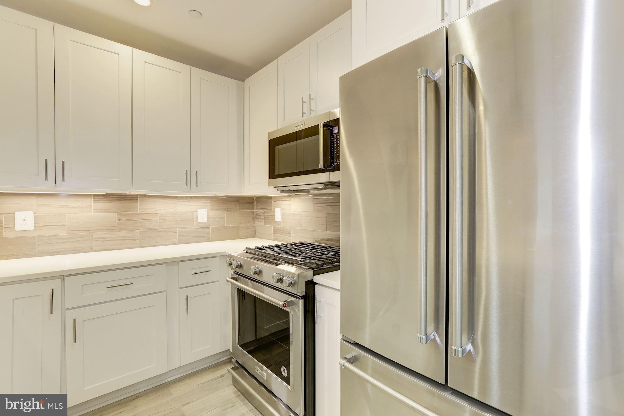 4008 Edmunds Street Northwest, Unit 6 Washington, DC 20007 - Photo 1 of 31 a kitchen with stainless steel appliances granite countertop white cabinets and refrigerator