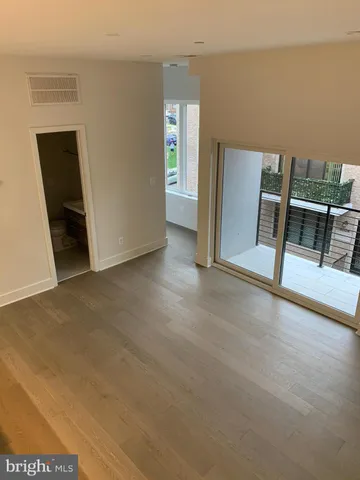 a view of an empty room with closet and windows
