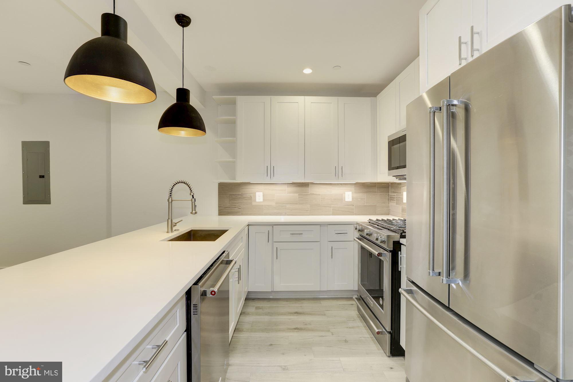 4008 Edmunds Street Northwest, Unit 6 Washington, DC 20007 - Photo 19 of 31 a kitchen with stainless steel appliances granite countertop a sink a stove and a refrigerator