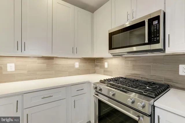 a kitchen with microwave cabinets and stove top oven