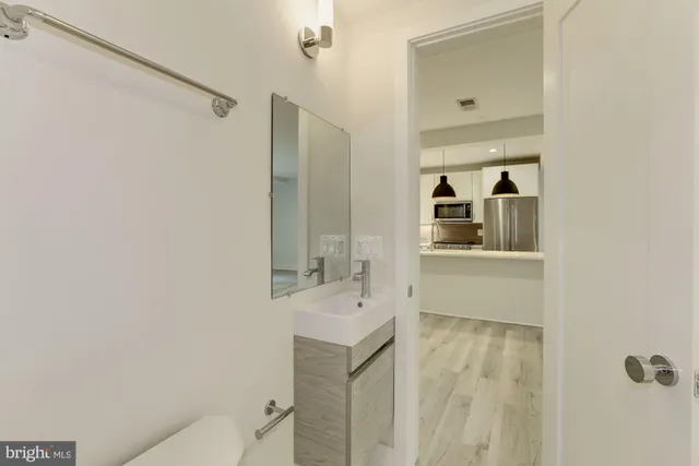 a bathroom with a sink and mirror with toilet