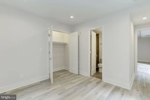 an empty room with wooden floor & windows