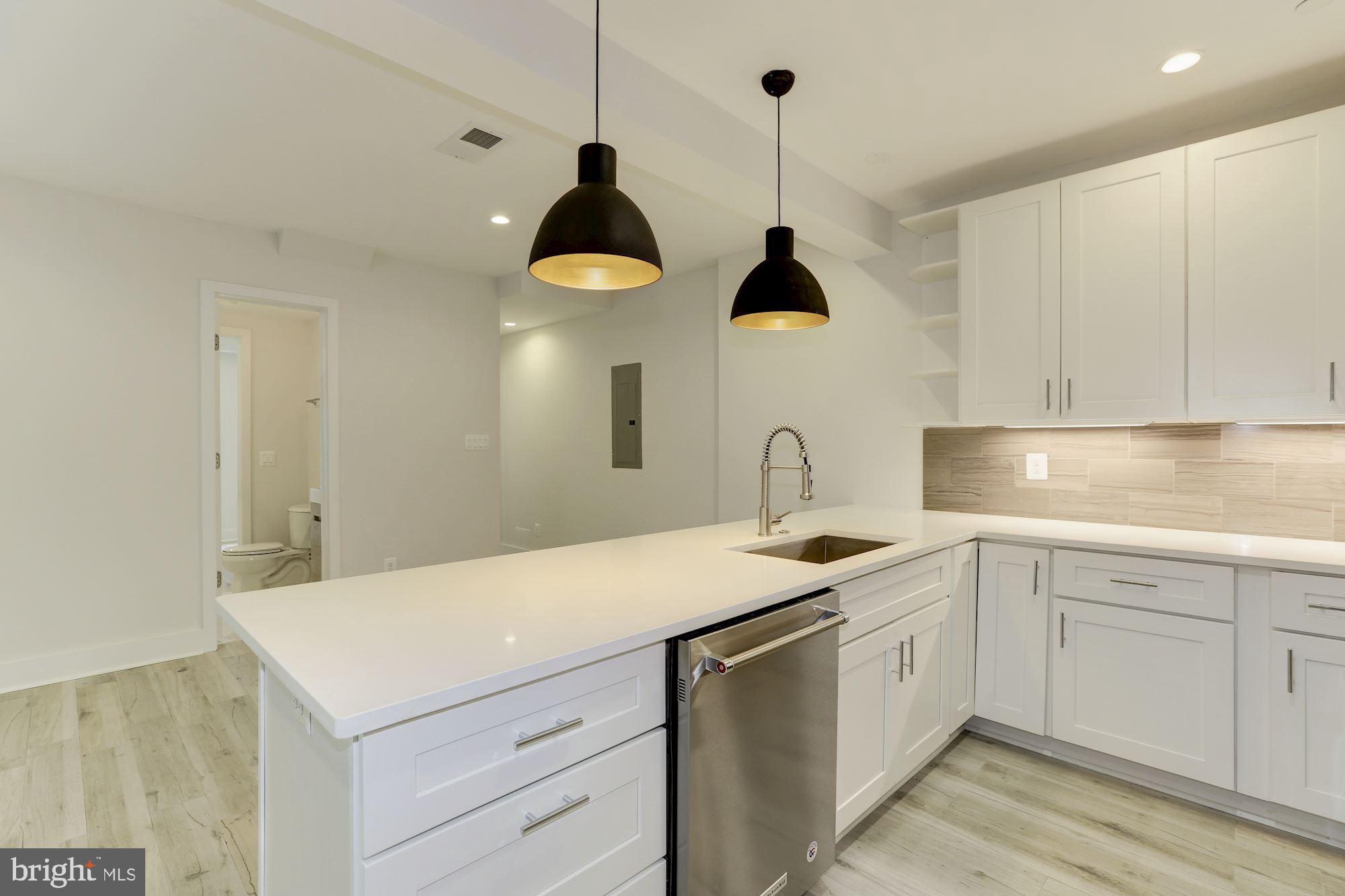 4008 Edmunds Street Northwest, Unit 6 Washington, DC 20007 - Photo 4 of 31 a kitchen with a sink dishwasher and a stove with white cabinets