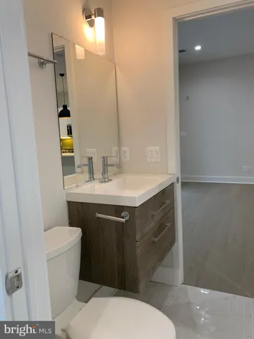 a bathroom with a sink toilet vanity and shower