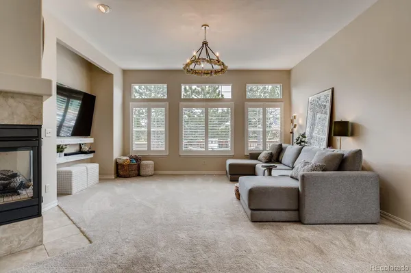 a living room with furniture a flat screen tv and a large window