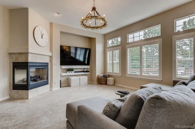a living room with furniture a flat screen tv and a large window