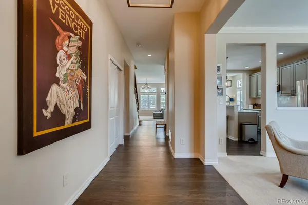 a view of a hallway with wooden floor and a bathroom