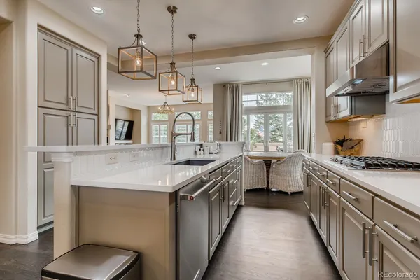 a kitchen with granite countertop a sink and a refrigerator
