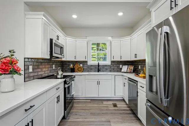 a kitchen with stainless steel appliances kitchen island a table and chair in it