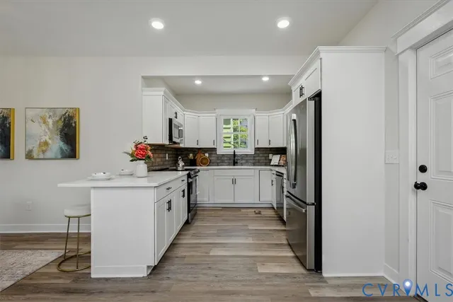 a kitchen with a sink stainless steel appliances cabinets and a window