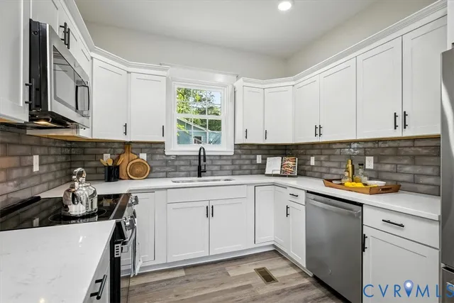 a kitchen with white cabinets and white appliances