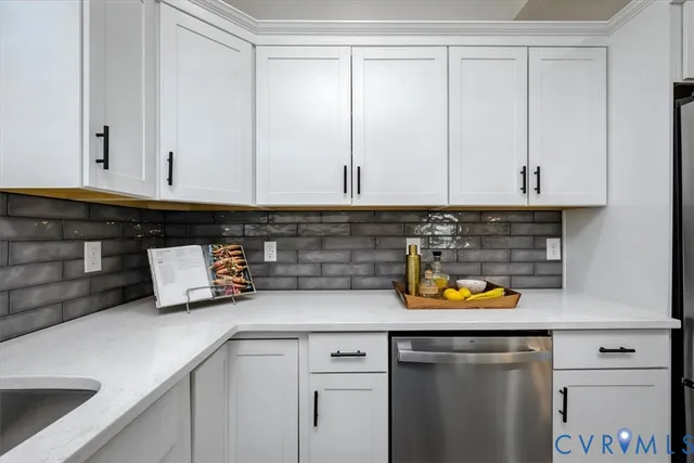 a kitchen with a sink white cabinets and window