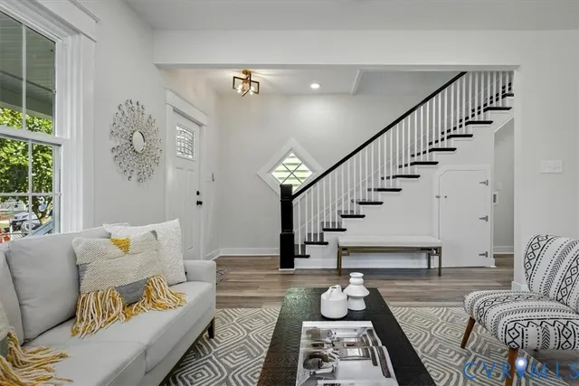 a living room with furniture a large window and a fireplace