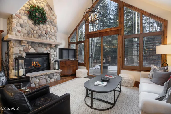 a living room with furniture a fireplace a lamp and a large window