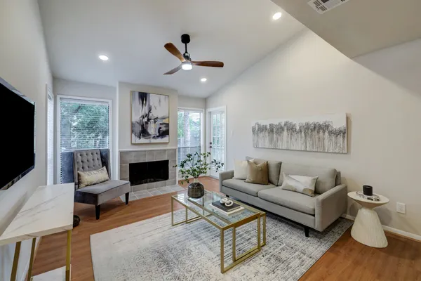 a living room with furniture a fireplace and a flat screen tv
