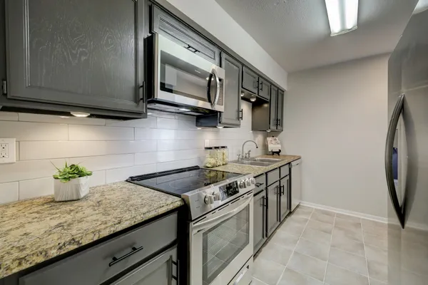 a kitchen with stainless steel appliances granite countertop a sink stove and microwave