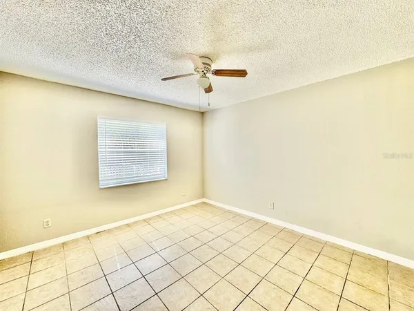 a view of a room with a ceiling fan and entryway