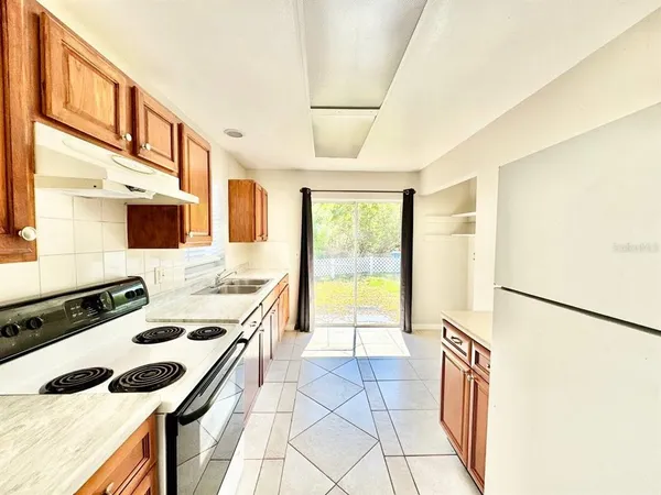 a large kitchen with stainless steel appliances granite countertop a sink and cabinets
