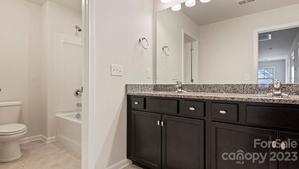 245 Fox Cove Road Hendersonville, NC 28792 - Photo 31 of 33 a bathroom with a granite countertop sink a toilet and with shower