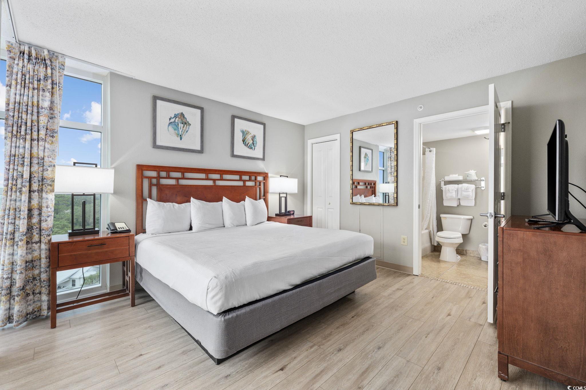 5200 North Ocean Boulevard, Unit 857 Myrtle Beach, SC 29577 - Photo 8 of 40 Bedroom featuring light wood-style floors, ensuite bath, a textured ceiling, and a closet