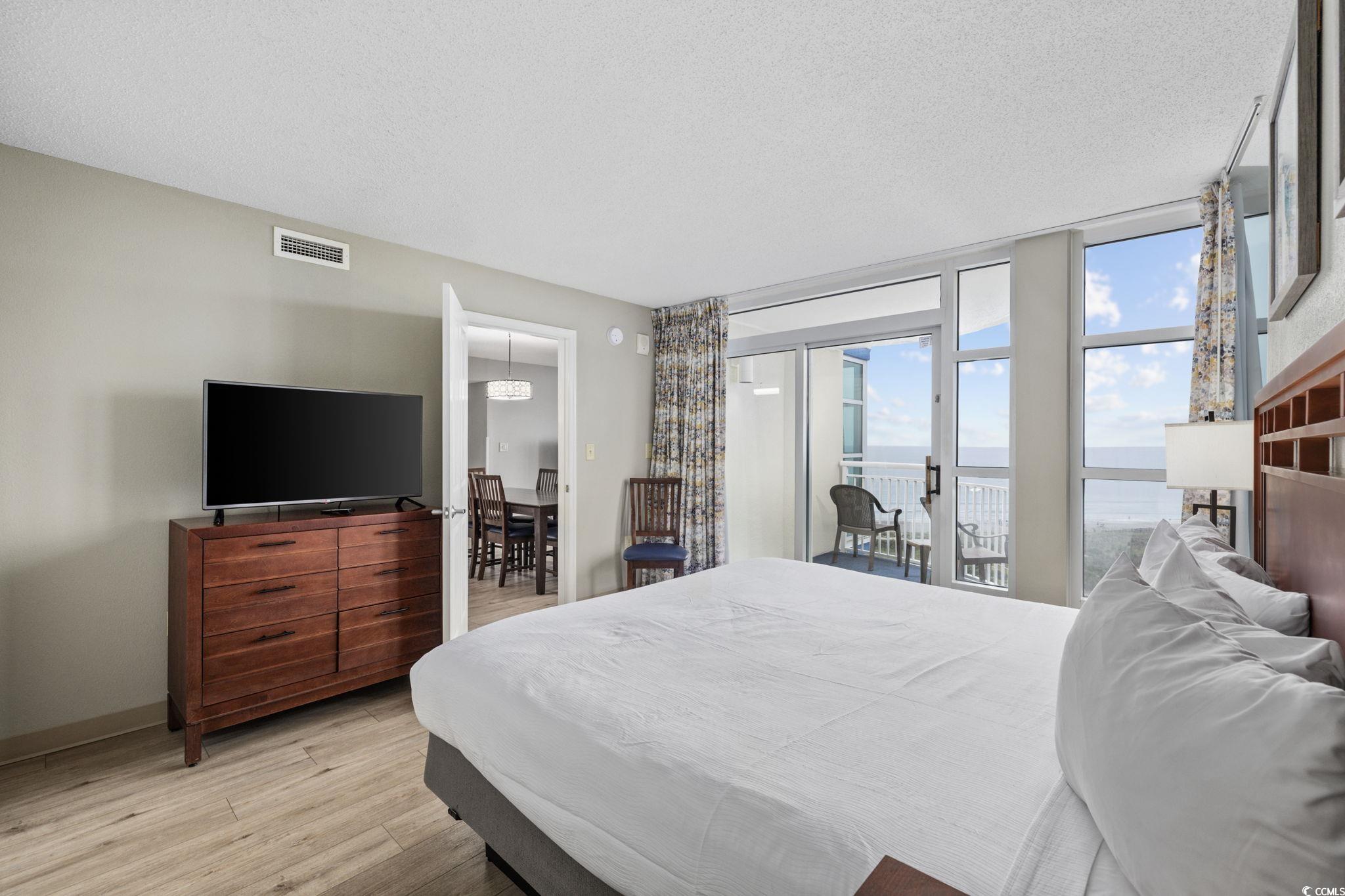 5200 North Ocean Boulevard, Unit 857 Myrtle Beach, SC 29577 - Photo 9 of 40 Bedroom featuring a textured ceiling, light wood-style flooring, and access to outside