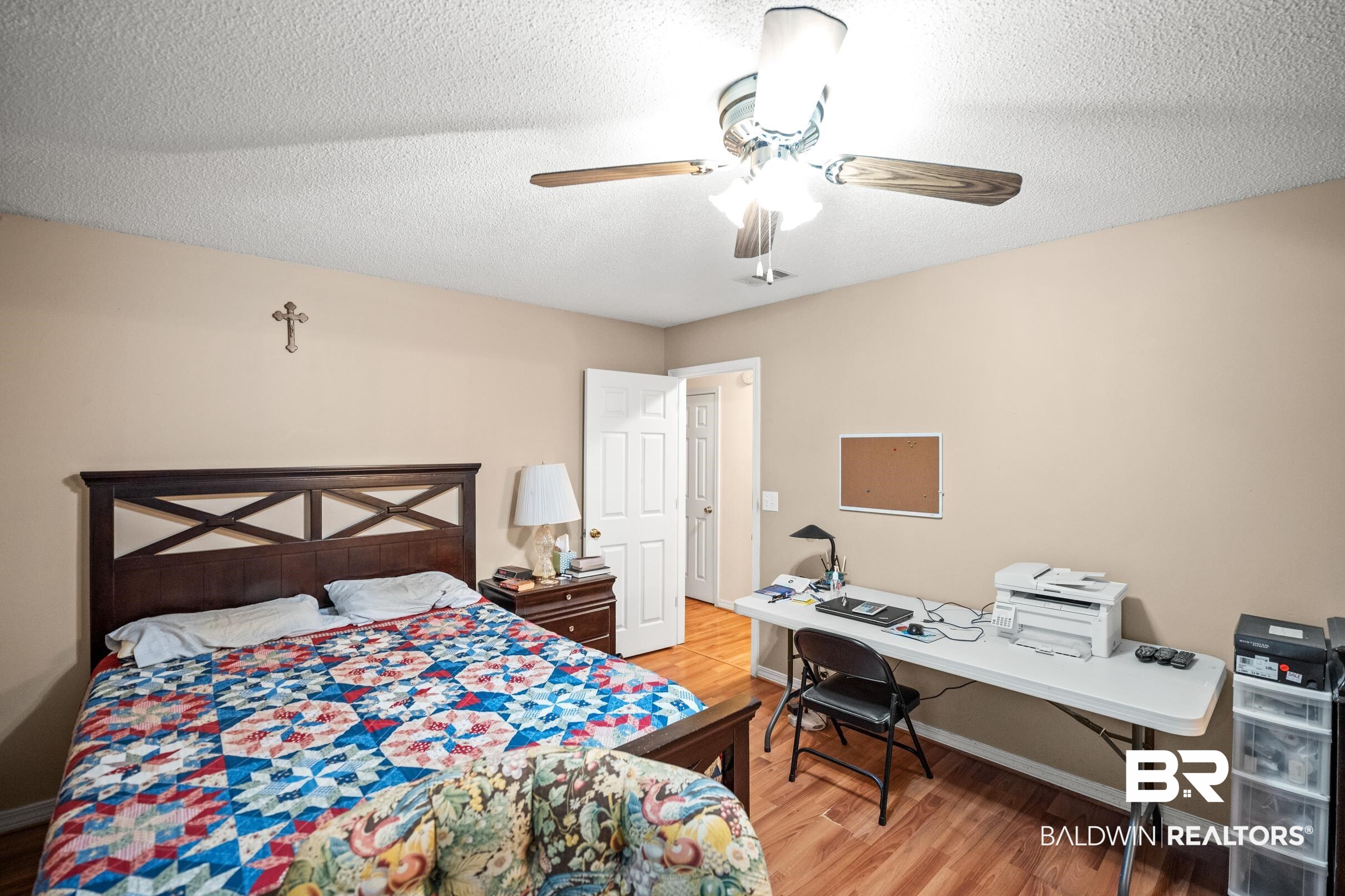 161 Robbins Boulevard Daphne, AL 36526 - Photo 16 of 23 Bedroom featuring a ceiling fan, baseboards, light wood finished floors, and a textured ceiling