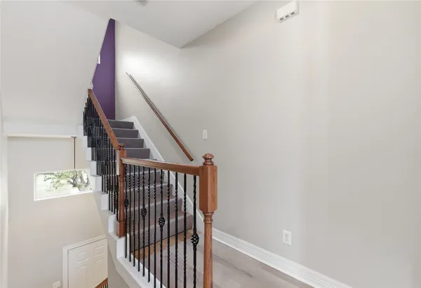 a kitchen with granite countertop a refrigerator a sink and white cabinets