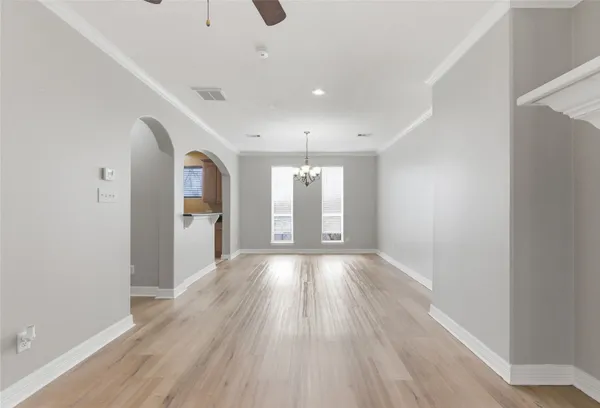 a view of an empty room with a fireplace and a ceiling fan
