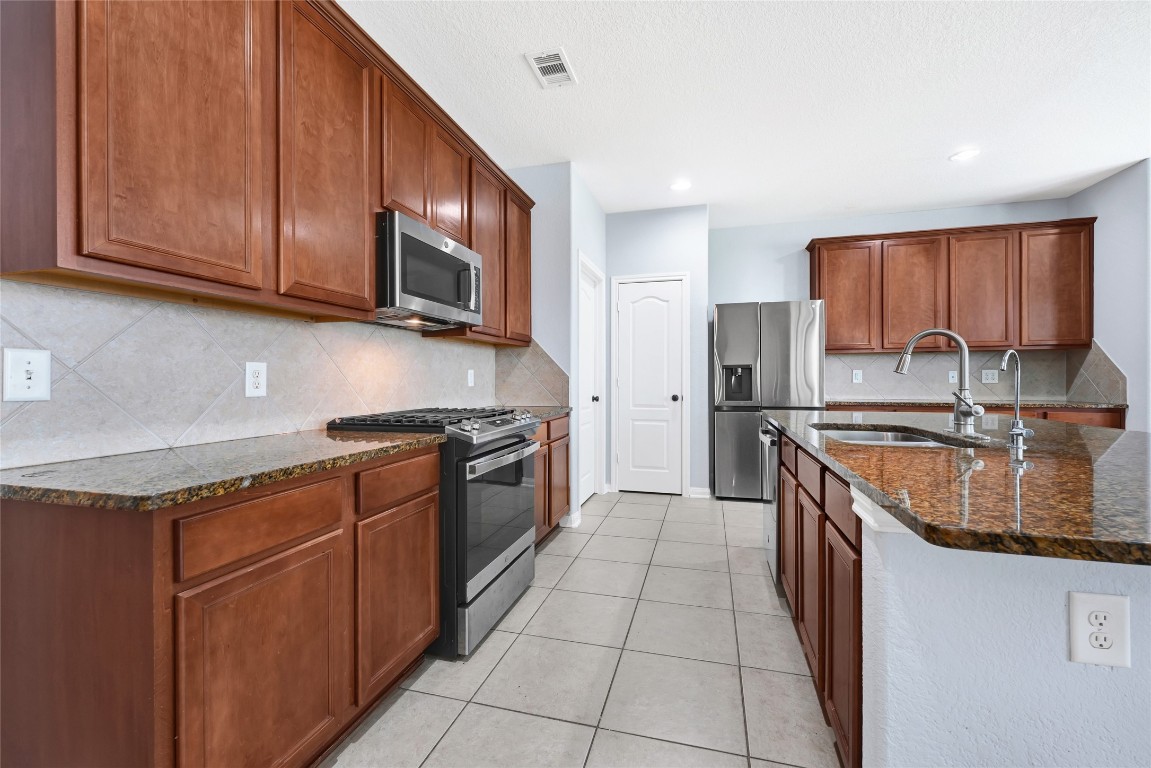 1501 Kent Valley Lane Rosenberg, TX 77471 - Photo 11 of 27 a kitchen with stainless steel appliances granite countertop a sink stove and refrigerator